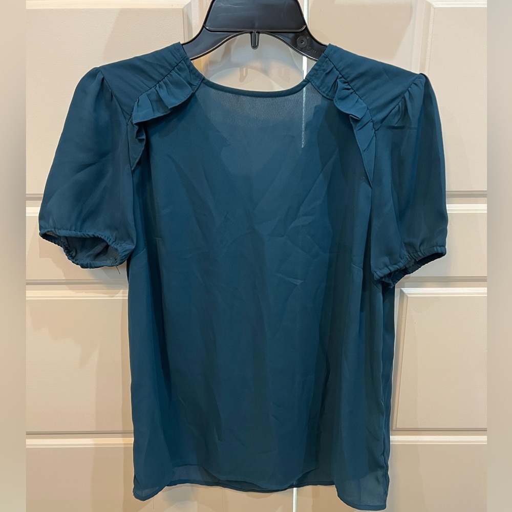Beautiful ruffle detail on front of blouse, short sleeve, button back closure